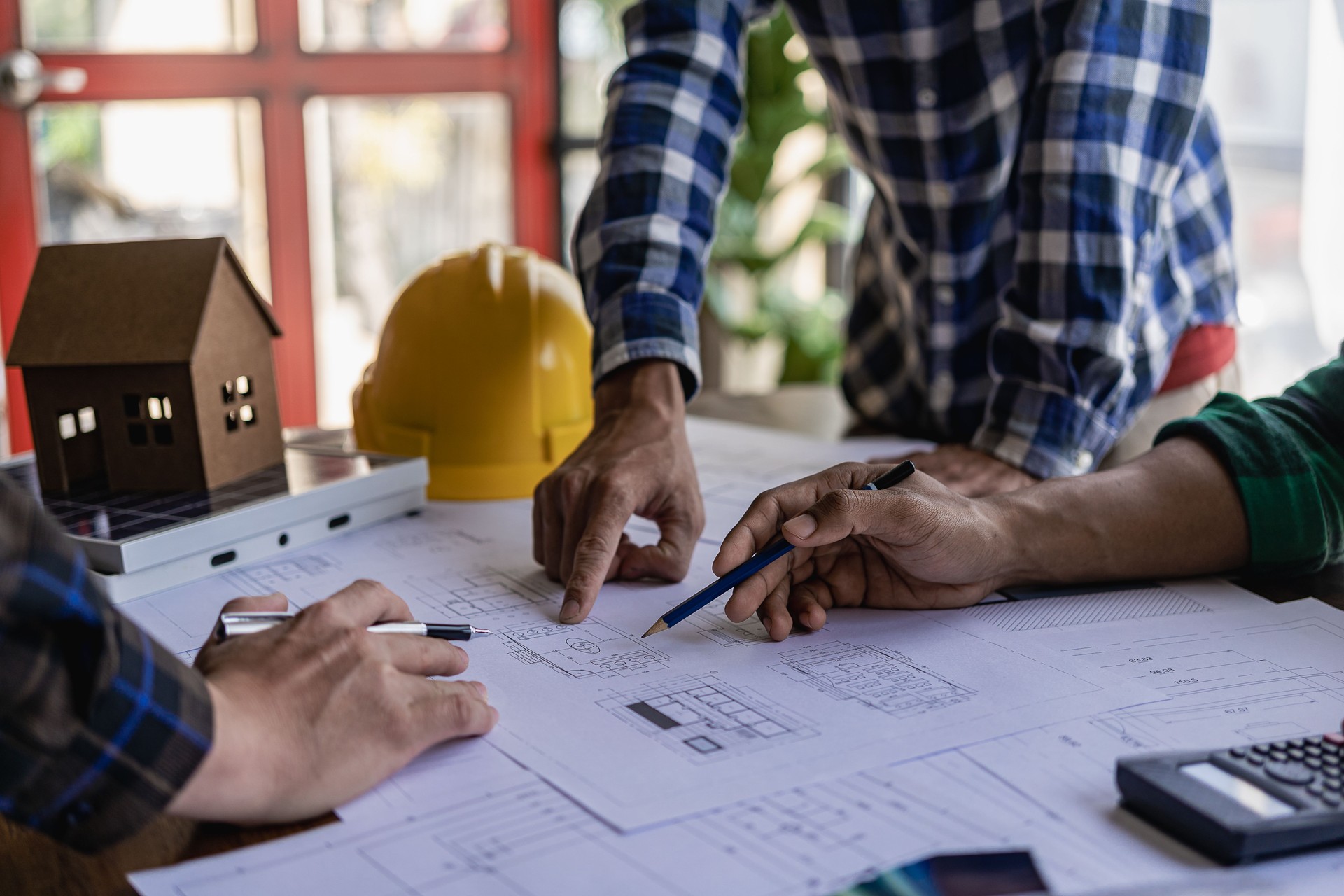 Group of engineers and working meeting and discussing construction planning with blueprints with architect equipment. Architects talking at table, teamwork and work flow construction concept.